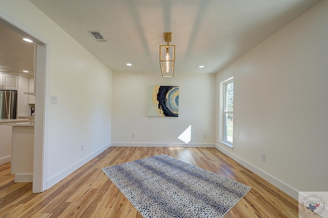 spare room with light hardwood / wood-style flooring