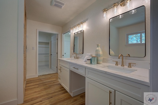 bathroom with hardwood / wood-style flooring, a textured ceiling, and vanity