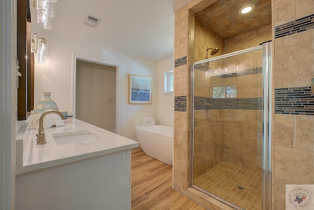 bathroom featuring hardwood / wood-style floors, separate shower and tub, and vanity