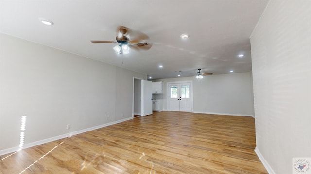 unfurnished living room featuring ceiling fan and light wood-type flooring