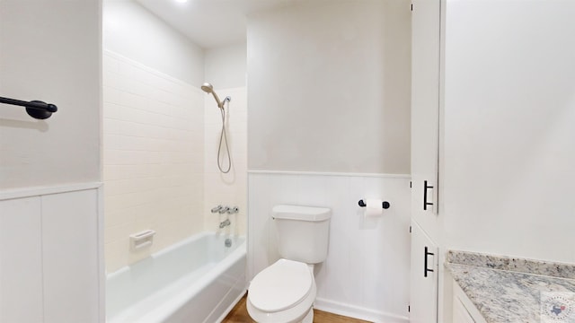 bathroom with tiled shower / bath combo and toilet