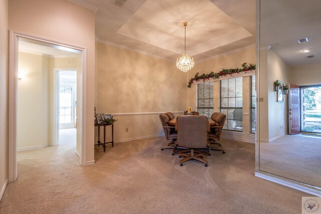 carpeted dining room with plenty of natural light and a raised ceiling