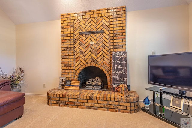 living room featuring a brick fireplace, lofted ceiling, and carpet flooring