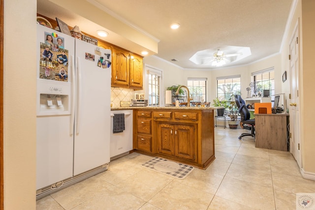 kitchen with kitchen peninsula, white refrigerator with ice dispenser, ceiling fan, backsplash, and ornamental molding