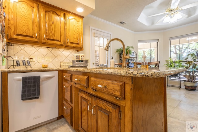 kitchen with light stone countertops, kitchen peninsula, and white dishwasher