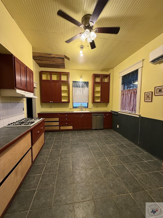 kitchen with appliances with stainless steel finishes, tasteful backsplash, an AC wall unit, sink, and ceiling fan