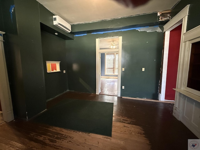 spare room featuring hardwood / wood-style floors and an AC wall unit