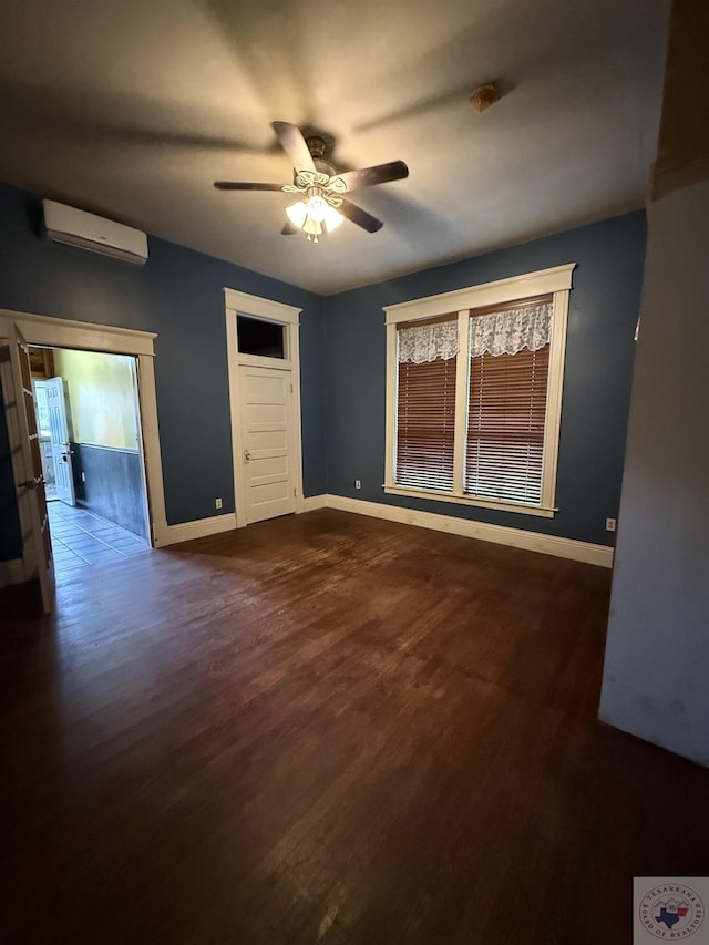 empty room featuring dark hardwood / wood-style floors, an AC wall unit, and ceiling fan