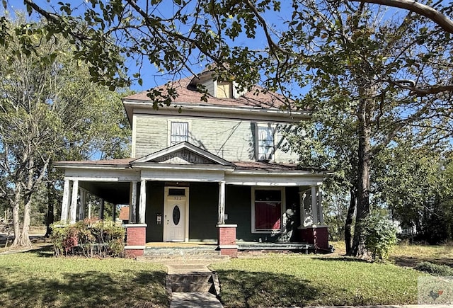 view of front facade featuring covered porch and a front yard
