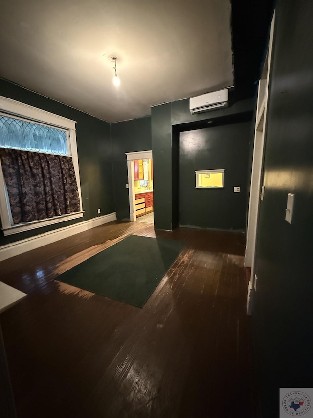 interior space featuring wood-type flooring and a wall unit AC