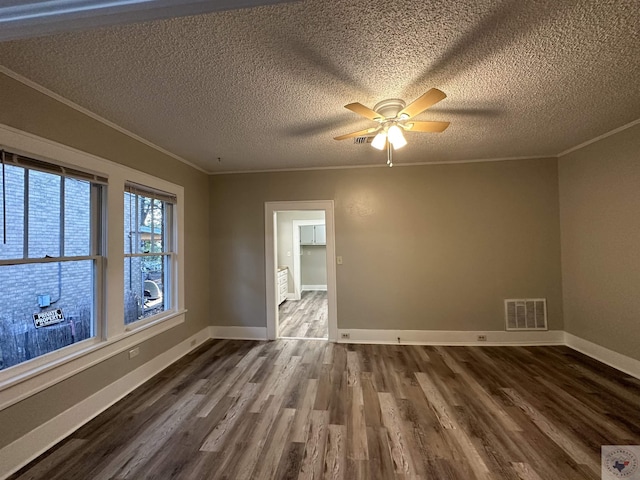 empty room featuring ceiling fan, wood-type flooring, ornamental molding, and a textured ceiling