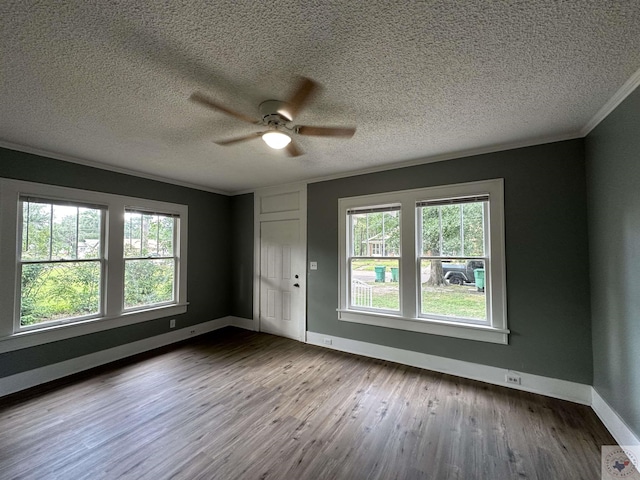 empty room featuring hardwood / wood-style flooring, a textured ceiling, ceiling fan, and a healthy amount of sunlight