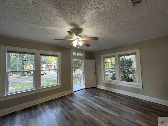 interior space featuring ceiling fan, dark wood-type flooring, a textured ceiling, and ornamental molding