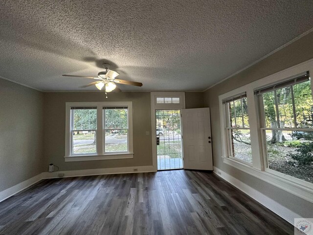 interior space featuring ceiling fan, ornamental molding, dark hardwood / wood-style flooring, and a textured ceiling