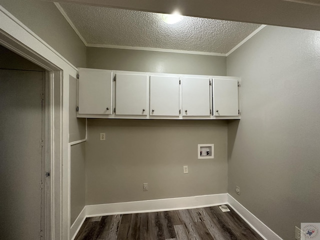 washroom with crown molding, a textured ceiling, hookup for a washing machine, dark hardwood / wood-style floors, and cabinets