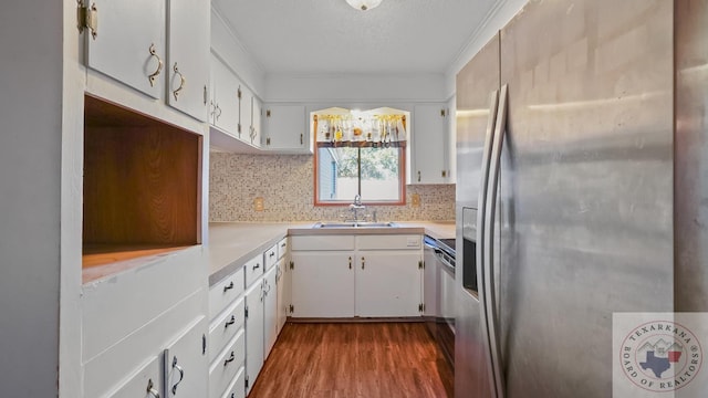 kitchen with wood-type flooring, stainless steel refrigerator with ice dispenser, sink, white cabinets, and decorative backsplash