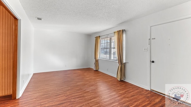 empty room featuring hardwood / wood-style floors and a textured ceiling