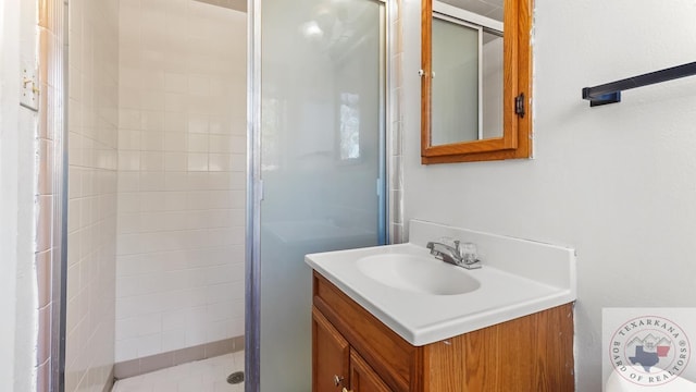 bathroom featuring a shower with door and vanity