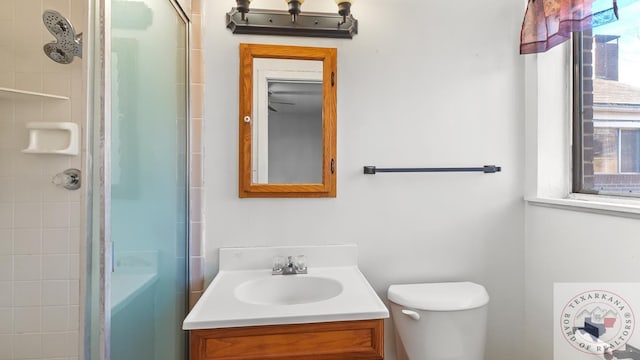 bathroom with toilet, vanity, and tiled shower