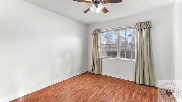 empty room with a textured ceiling, dark hardwood / wood-style floors, and ceiling fan