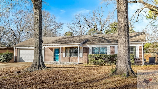 ranch-style house featuring a garage and cooling unit