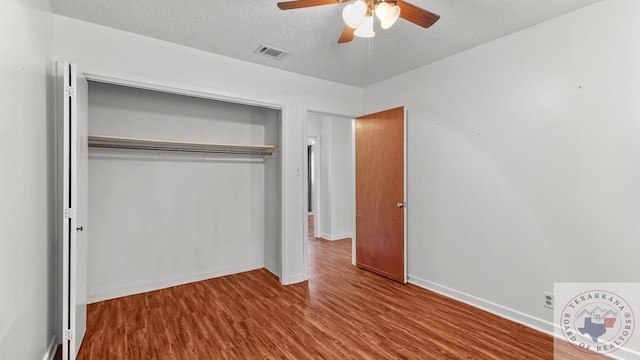 unfurnished bedroom featuring a closet, ceiling fan, a textured ceiling, and wood-type flooring