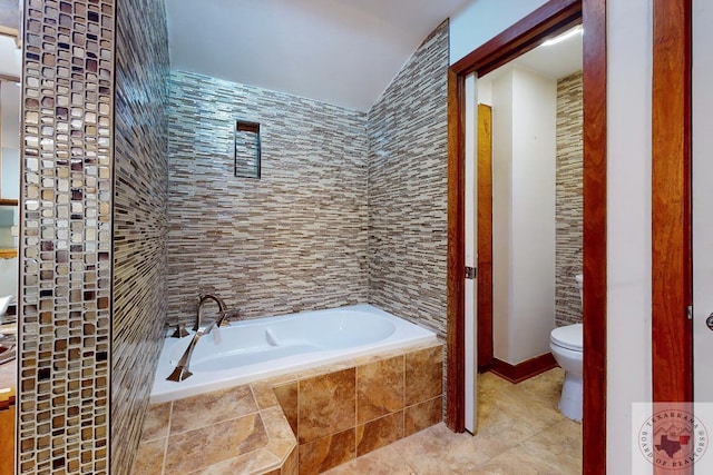 bathroom featuring tiled tub and toilet