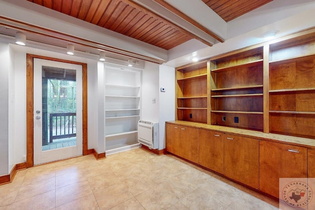 interior space featuring heating unit and beam ceiling