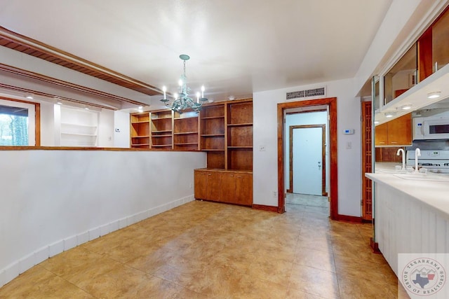 unfurnished dining area with sink and a notable chandelier