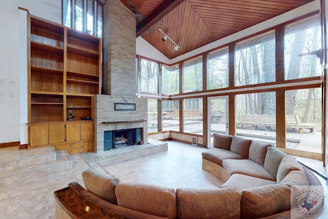 living room with a high ceiling, a fireplace, and wooden ceiling