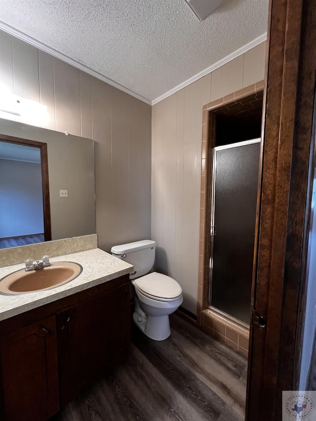 bathroom featuring wood-type flooring, crown molding, an enclosed shower, a textured ceiling, and vanity