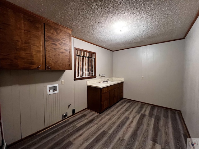 clothes washing area with sink, cabinets, washer hookup, and ornamental molding