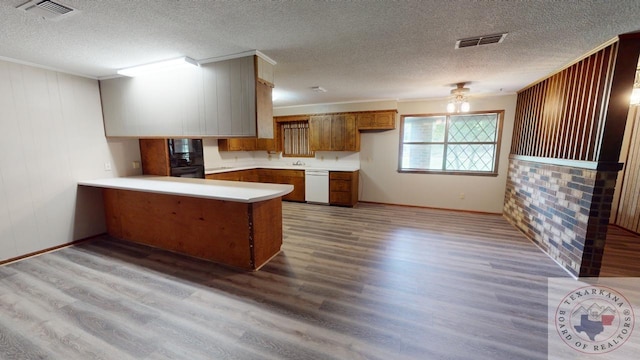 kitchen with ornamental molding, black appliances, kitchen peninsula, and light wood-type flooring