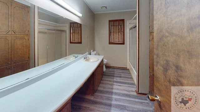 full bathroom featuring vanity, toilet, enclosed tub / shower combo, and crown molding