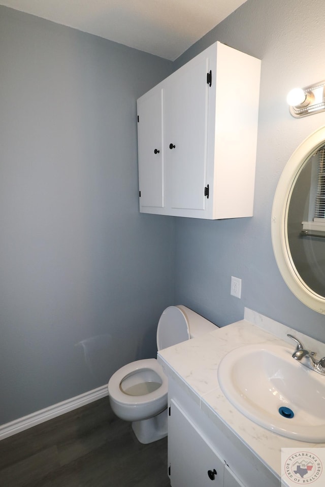 bathroom featuring vanity, toilet, and hardwood / wood-style floors