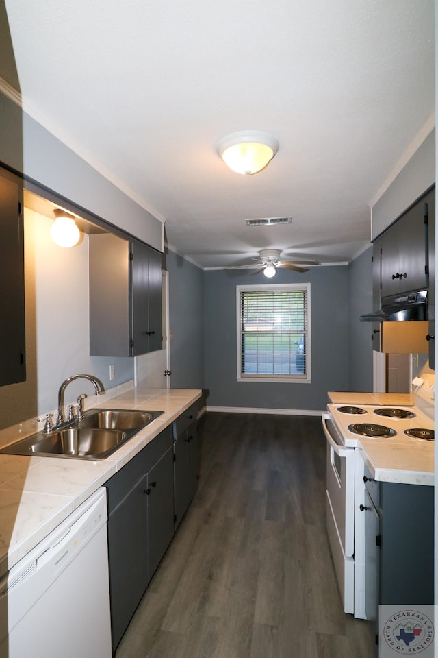 kitchen with sink, white appliances, crown molding, and dark hardwood / wood-style flooring