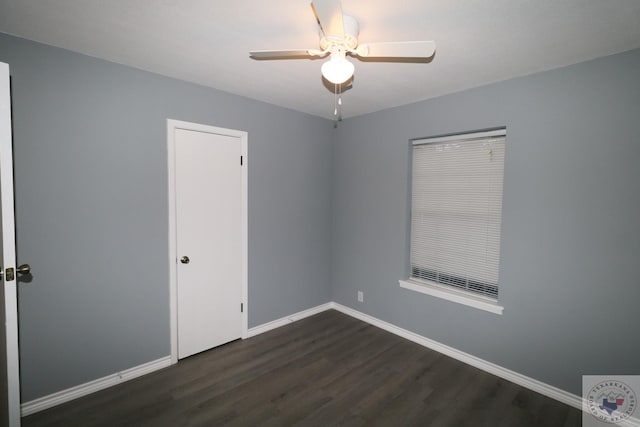 empty room with ceiling fan and dark hardwood / wood-style flooring