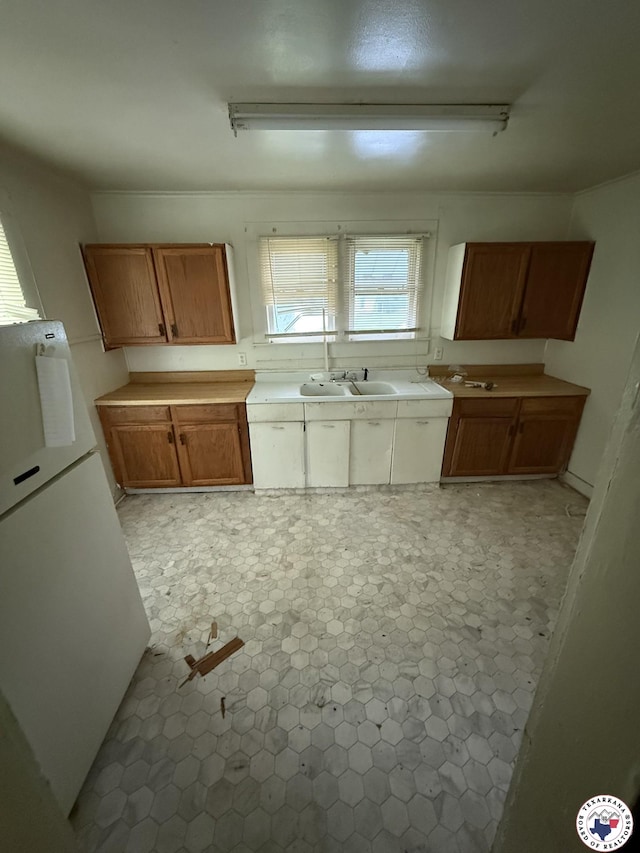 5853 Wallace Rd, Texarkana, AR 71854 - kitchen featuring freestanding refrigerator, brown cabinetry, and a sink