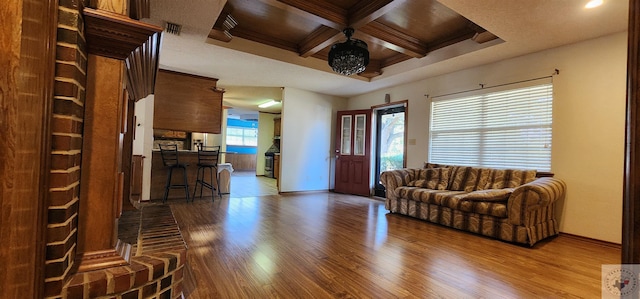 living room with wood-type flooring, beam ceiling, and coffered ceiling