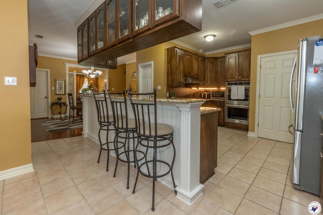 7 Brittan Pl, Texarkana, TX 75503 - kitchen featuring stainless steel appliances, a kitchen breakfast bar, ornamental molding, glass insert cabinets, and light tile patterned floors