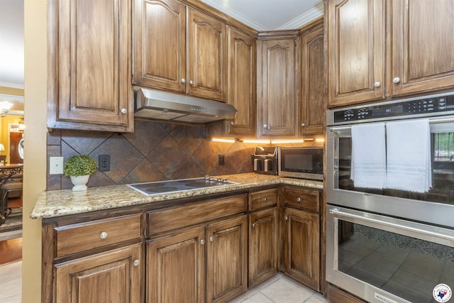 7 Brittan Pl, Texarkana, TX 75503 - kitchen featuring under cabinet range hood, appliances with stainless steel finishes, crown molding, decorative backsplash, and light stone counters
