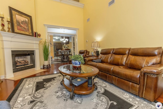 7 Brittan Pl, Texarkana, TX 75503 - living area with wood finished floors, a chandelier, a towering ceiling, and a fireplace with flush hearth