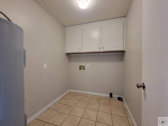 laundry area featuring washer hookup, cabinets, a textured ceiling, and light tile patterned flooring