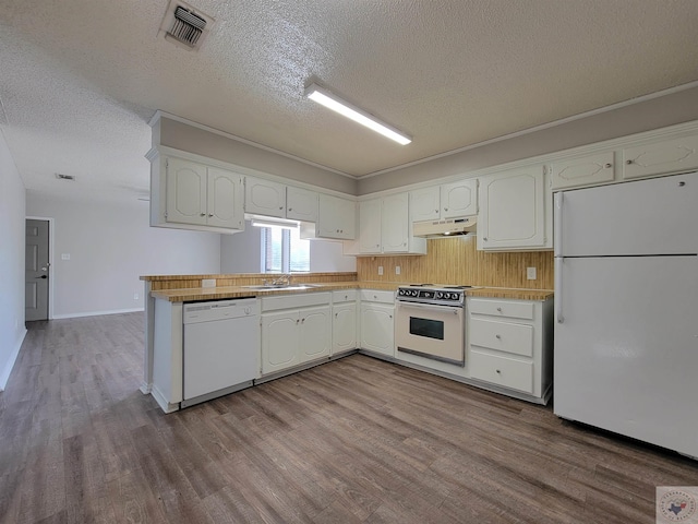 kitchen featuring sink, white appliances, a textured ceiling, and white cabinets