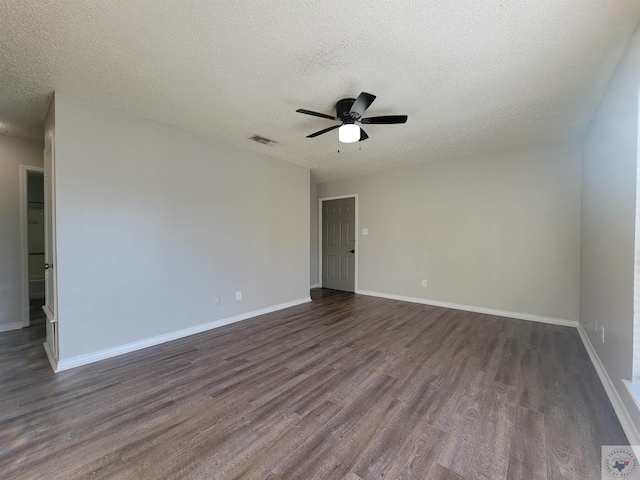 empty room with a textured ceiling, ceiling fan, and dark hardwood / wood-style flooring