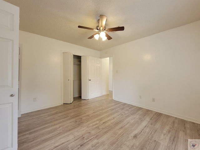 unfurnished bedroom with ceiling fan, a textured ceiling, light hardwood / wood-style flooring, and a closet