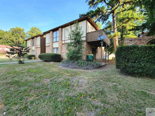 view of side of home featuring a balcony and a lawn