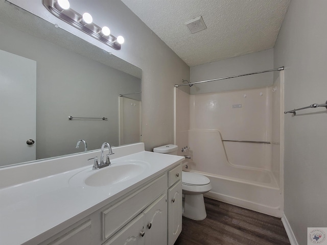 full bathroom featuring tub / shower combination, hardwood / wood-style flooring, toilet, a textured ceiling, and vanity