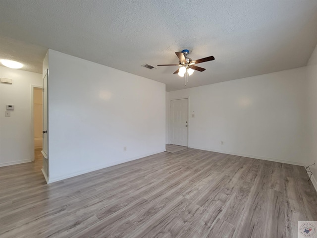 unfurnished room featuring ceiling fan, light hardwood / wood-style flooring, and a textured ceiling