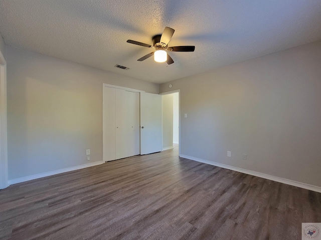 unfurnished bedroom with a closet, ceiling fan, hardwood / wood-style floors, and a textured ceiling